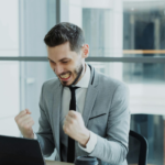 Homem comemorando sucesso em escritório, alusivo a adiantar precatório.